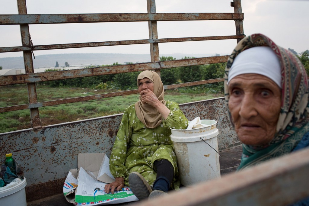 Falama, Palestine - 04/08/2015: Two women wait patiently in their farm vehicle for Israel to open the separation barrier to allow them access to their farmland. There are only three half hour openings per day and 300 farmers queueing for access, some denied entry on a dally basis.